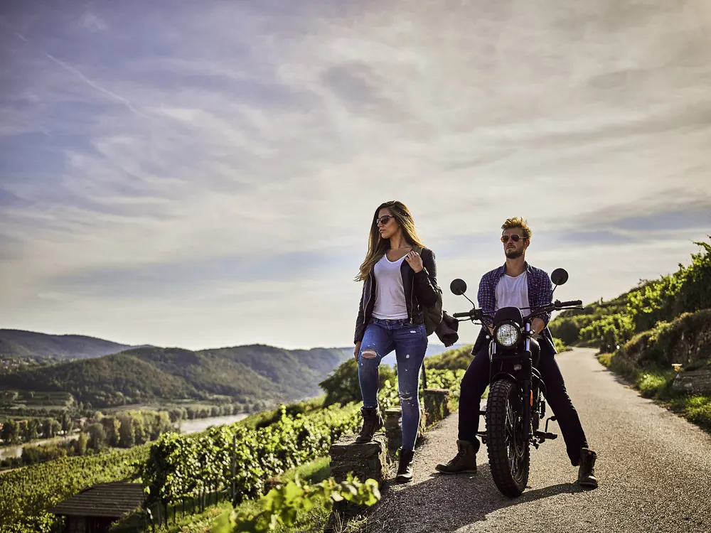Paar mit Motorrad in den Weinbergen